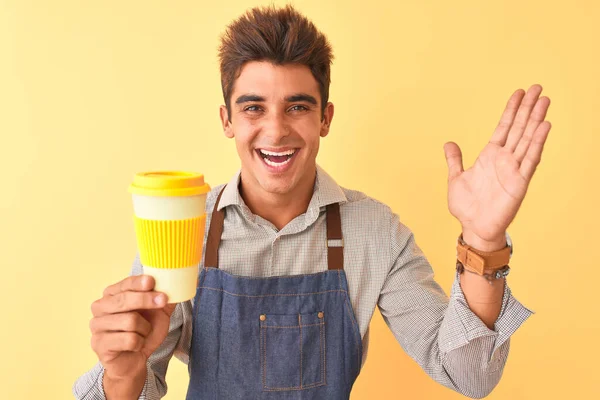 Joven Barista Guapo Con Delantal Sosteniendo Café Sobre Fondo Amarillo — Foto de Stock