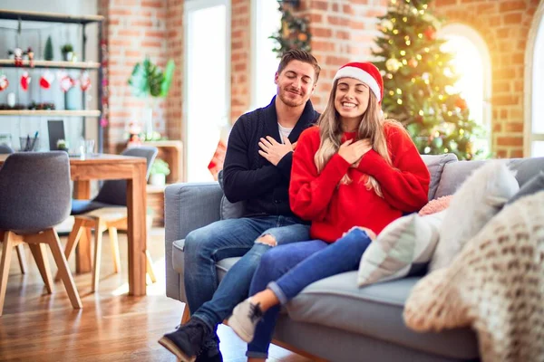 Ein Junges Paar Mit Weihnachtsmannmütze Sitzt Hause Auf Dem Sofa — Stockfoto