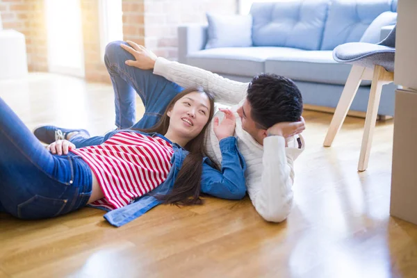 Young asian couple lying on the floor of new house arround cardb