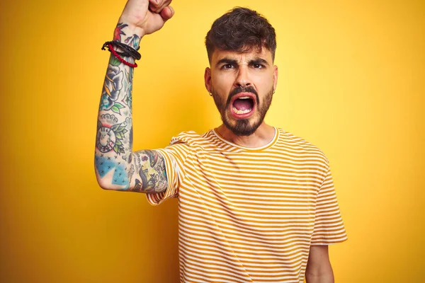 Jovem Com Tatuagem Vestindo Camiseta Listrada Sobre Fundo Amarelo Isolado — Fotografia de Stock