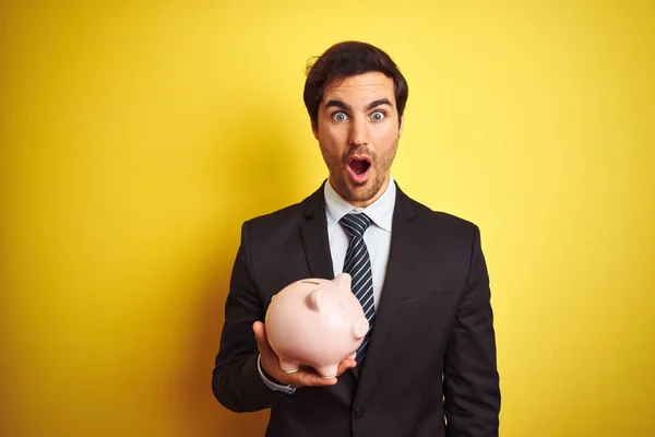 Young Handsome Businessman Holding Piggy Bank Isolated Yellow Background Scared — Stock Photo, Image