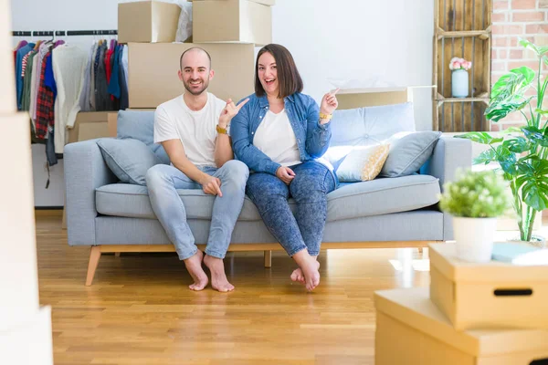 Junges Paar Sitzt Auf Dem Sofa Inmitten Von Kartons Die — Stockfoto