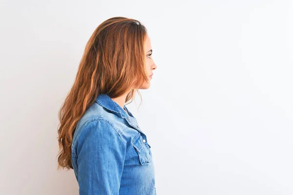 年轻的红头发女人穿着斜纹棉布夹克站在孤立的背景图旁边 带着自信的微笑放松自己的姿态 — 图库照片
