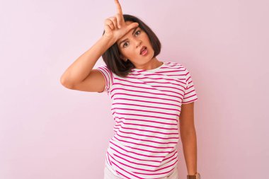 Çizgili tişört giyen genç güzel bir kadın pembe arka planda dikiliyor. Alnında parmakları olan insanlarla dalga geçiyor. Ezik hareketler yapıyor, alay ediyor ve hakaret ediyor..