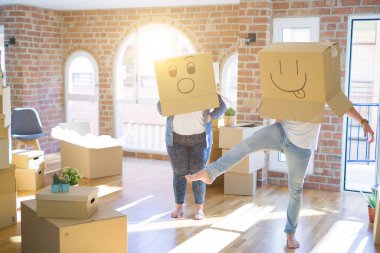Komik emoji ile karton kutular giyen çılgın çift kafa üzerinde yüzler, yeni evde eğlenmek