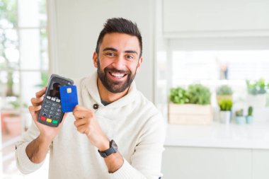 İş adamı gülümseyerek ve satış noktası terminal ve cred tutma