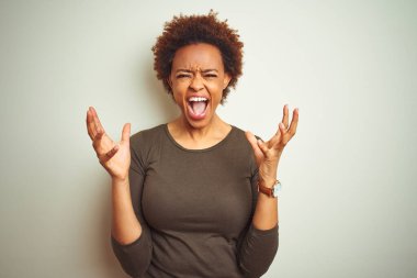 Izole arka plan üzerinde afro saçlı genç güzel Afro-Amerikan kadın kollarını kaldırdı ve kapalı gözleri heyecan çığlık ile başarı için deli ve deli kutluyor. Kazanan kavramı