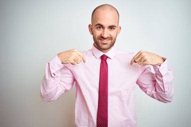 Pembe kravat takan genç bir iş adamı izole edilmiş arka planda kendine güvenen, yüzünde bir gülümsemeyle kendini gururlu ve mutlu bir şekilde gösteren bir adam..
