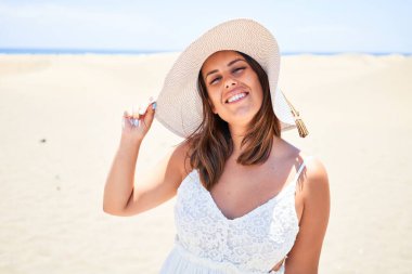 Genç ve güzel bir kadın gülümsüyor. Mutlu bir yaz tatili geçiriyor. Masalomas Kumsalında.