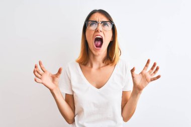 Güzel kızıl saçlı kadın gözlük takıyor arka planda deli deli deli bağırıyor ve agresif bir ifadeyle bağırıyor ve kollarını kaldırıyor. Hayal kırıklığı konsepti.
