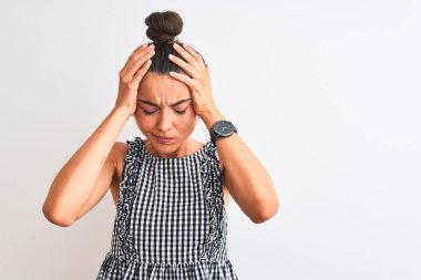 Çörek giymiş güzel bir kadın izole edilmiş beyaz arka planda dikilip acı ve migren yüzünden baş ağrısı çeken çaresiz ve stresli bir şekilde duruyor. Ellerini başının üstüne koy..