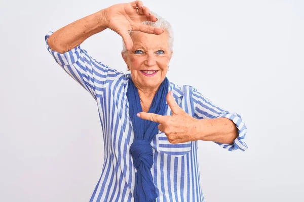高个子灰白头发的女人穿着蓝色条纹衬衫 站在孤立的白色背景上 微笑着 用双手和手指制作出笑脸的框架 创意和摄影概念 — 图库照片