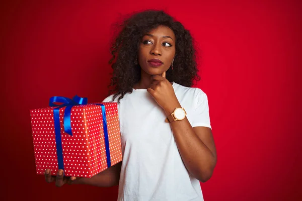 Mujer Afroamericana Joven Sosteniendo Regalo Cumpleaños Pie Sobre Fondo Rojo — Foto de Stock