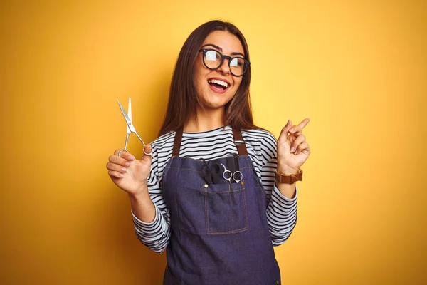 Young Beautiful Hairdresser Woman Holding Scissors Standing Isolated Yellow Background — Zdjęcie stockowe