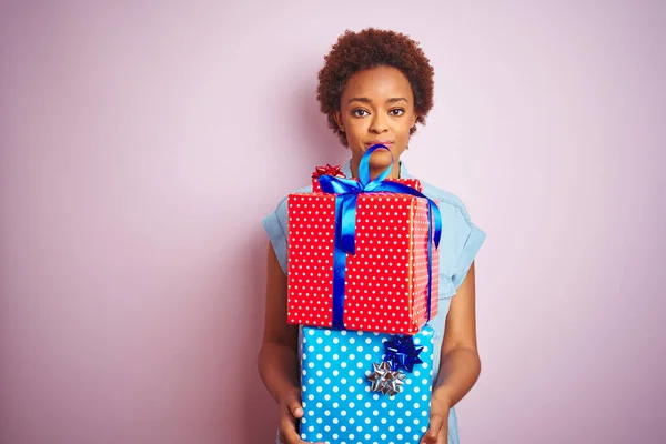 Afrikanische Amerikanerin Hält Geburtstagsgeschenke Über Rosa Isoliertem Hintergrund Mit Einem — Stockfoto
