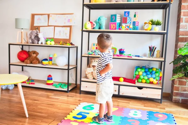 Schöner Kleinkind Junge Steht Mit Vielen Spielsachen Kindergarten — Stockfoto