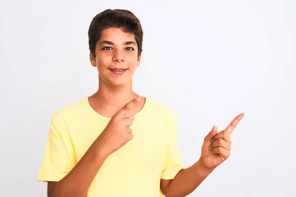 英俊的少年男孩站在白色孤立的背景上微笑着 看着摄像机 用双手和手指指向旁边 — 图库照片