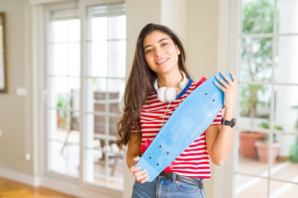 Hermosa mujer skater sonriendo amistoso de pie con monopatín — Foto de Stock