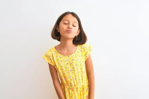 年轻美丽的小女孩穿着黄色的花裙子 站在孤独的白色背景上 看着摄像机在空气中飞吻着可爱而性感的女孩 爱的表达 — 图库照片