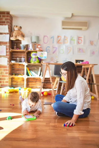 Hermoso Maestro Dibujo Infantil Utilizando Tablero Digital Alrededor Montón Juguetes —  Fotos de Stock