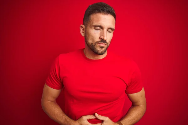 年轻英俊的男子穿着休闲的T恤 背负着红色的孤立的背景 手放在肚子上 因为消化不良 疼痛的疾病感觉不舒服 阿切概念 — 图库照片