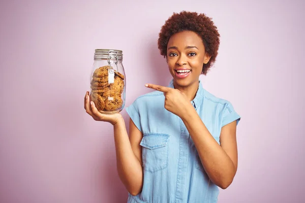 Африканська Американка Яка Тримає Руках Глечик Шоколадного Печива Над Рожевим — стокове фото