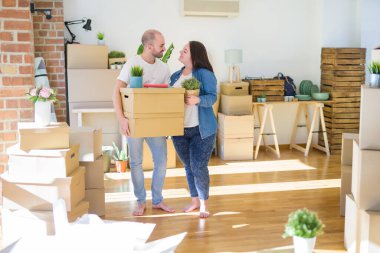 Genç çift yeni bir eve hareket, mutlu tutan karton kutular gülümseyen