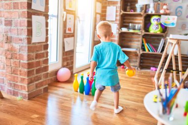Anaokulunda oyuncaklarla oynayan beyaz bir çocuk. Anaokulu çocuğu oyun odasında mutlu..