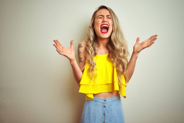 Beyaz izole arka plan üzerinde ayakta sarı t-shirt giyen genç güzel kadın deli ve silah ile başarı için deli kutluyor kaldırdı ve heyecanlı çığlık kapalı gözleri. Kazanan kavramı