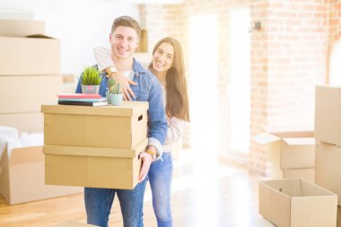 Karton kutular tutan aşk gülümseyen güzel genç çift, 