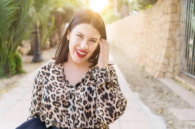 Bahçede mutlu gülümseyen kırmızı dudaklı genç güzel kadın