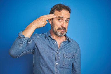 Yakışıklı, orta yaşlı, gri saçlı, soyutlanmış mavi geçmişi olan bir adam. Kendini vuruyor ve öldürüyor. Silah gibi el ve parmaklarını işaret ediyor..