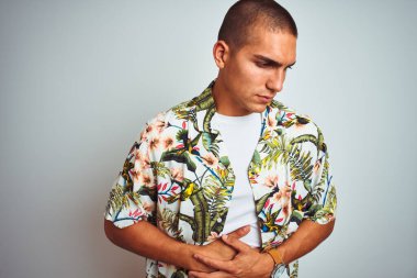 Tatilde genç yakışıklı bir adam beyaz arka planda Hawaii tişörtü giyiyor. Midesi bulanıyor, acı verici bir hastalığı var. Ache kavramı.