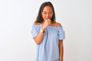 Mavi tişört ve gözlük takan Çinli genç bir kadın izole edilmiş beyaz arka planda kendini kötü hissediyor ve soğuk algınlığı veya bronşitin belirtisi olarak öksürüyor. Sağlık hizmetleri kavramı.