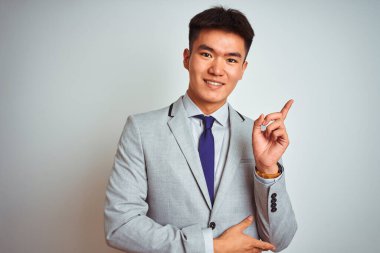 Asyalı Çinli işadamı gri kravat takıyor. İzole edilmiş beyaz arka planda duruyor. Yüzünde kocaman bir gülümseme var..