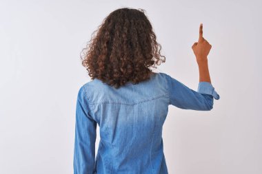 İzole edilmiş beyaz arka planda duran kot gömlek giyen genç Brezilyalı kadın geriye doğru poz veriyor.