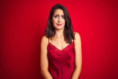 Genç ve güzel bir kadın, kırmızı iç çamaşırları üzerine seksi iç çamaşırları giyiyor. Depresyonda ve üzüntüden ağlıyor, ağlıyor ve korkuyor. Üzücü ifade.