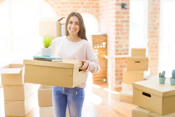 Bella giovane donna sorridente felice trasferirsi in una nuova casa, molto e — Foto Stock