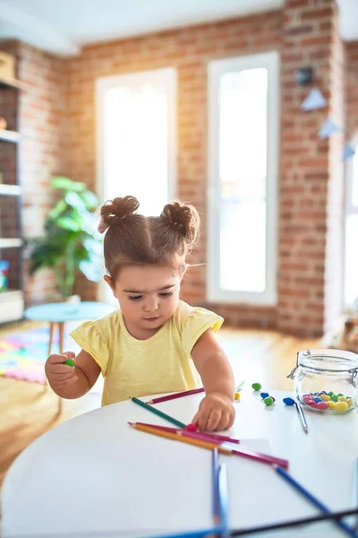 유치원 테이블 위에서 초콜릿 색깔의 가지고 아름다운 아기가 — 스톡 사진