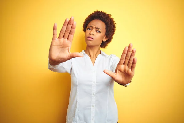 African american business woman over isolated yellow background doing frame using hands palms and fingers, camera perspective