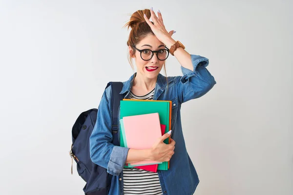 頭の上に手で 恥と驚きの顔で 怒っていると不満ショックを受けた学生の女性は 孤立した白い背景の上に本を保持バックパックを着ている 恐怖と過ちへの動揺 — ストック写真