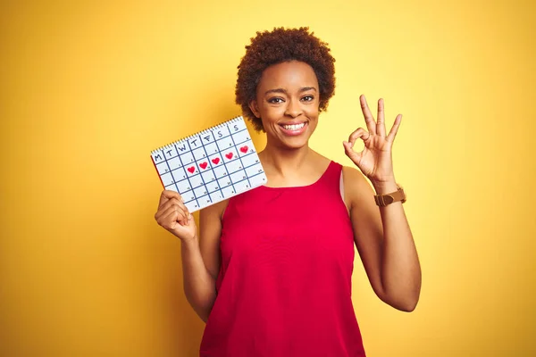 Jonge Afro Amerikaanse Vrouw Met Menstruatiekalender Geïsoleerde Gele Achtergrond Doet — Stockfoto