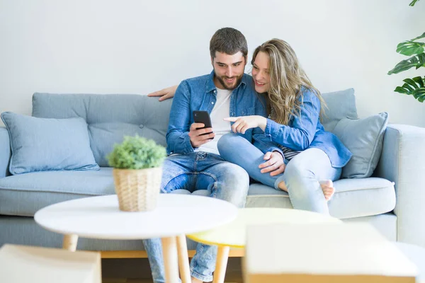 Mladý Pár Láskou Pohovce Sedí Používá Smartphone Velmi Šťastné Stěhování — Stock fotografie