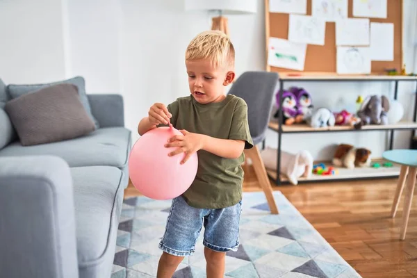 ピンクの風船で幼稚園で遊んでいる若い白人の子供 未就学児の男の子幸せとともにPlayroomとともにおもちゃ — ストック写真