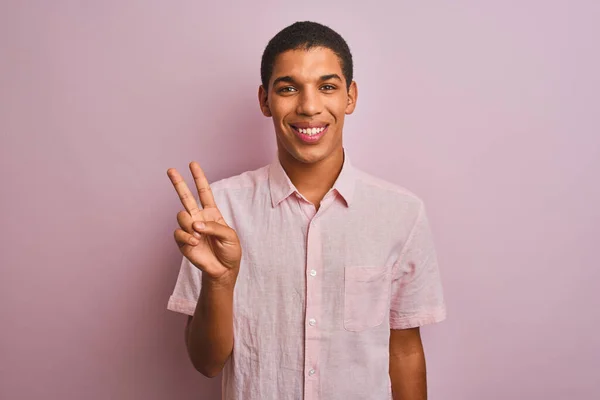 年轻英俊的阿拉伯男子 身穿休闲装 站在孤立的粉色背景上 用手指指了指二号 面带微笑 自信而快乐 — 图库照片