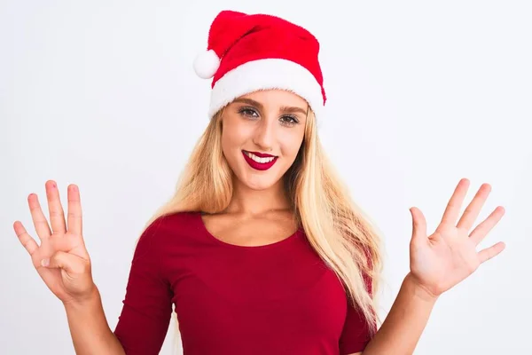 若いです美しいです女性身に着けていますクリスマスサンタ帽子上の隔離された白い背景ショーと指差し込み指番号9ながら笑顔自信と幸せ — ストック写真