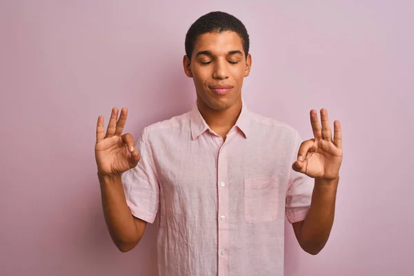 年轻英俊的阿拉伯男子穿着休闲装 站在孤立的粉色背景上放松 闭上双眼微笑 用手指做冥想手势 瑜伽概念 — 图库照片