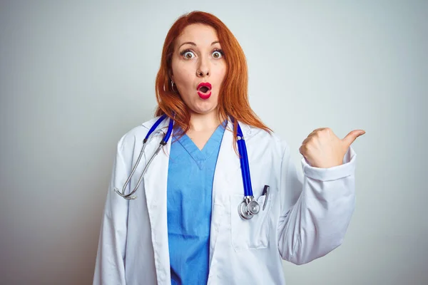 Joven Doctora Pelirroja Usando Estetoscopio Sobre Fondo Blanco Aislado Sorprendido —  Fotos de Stock