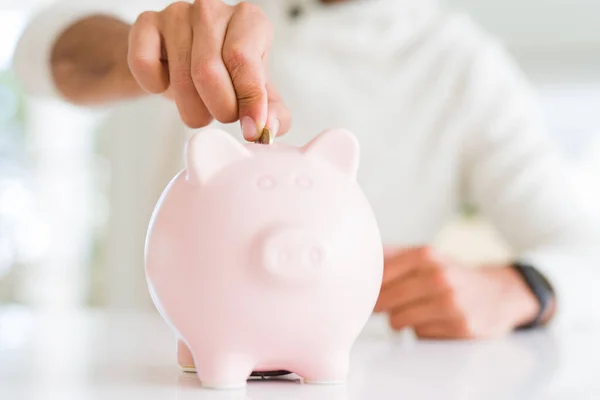 Hombre poniendo una moneda dentro de alcancía ahorro para la inversión —  Fotos de Stock