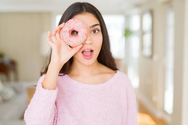 Hermosa joven mujer mirando a través de rosquilla en el ojo con —  Fotos de Stock